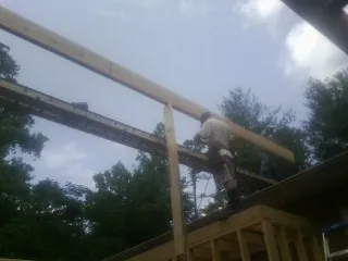Carpenter setting a ridge beam over a new addition frame — Ice Dam Removal by Roofing Brothers in Ruther Glen