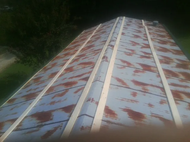 Rusted metal roof panels with new wood purlins before replacement — Storm Damage Roof Repair in Ruther Glen by Roofing Brothers