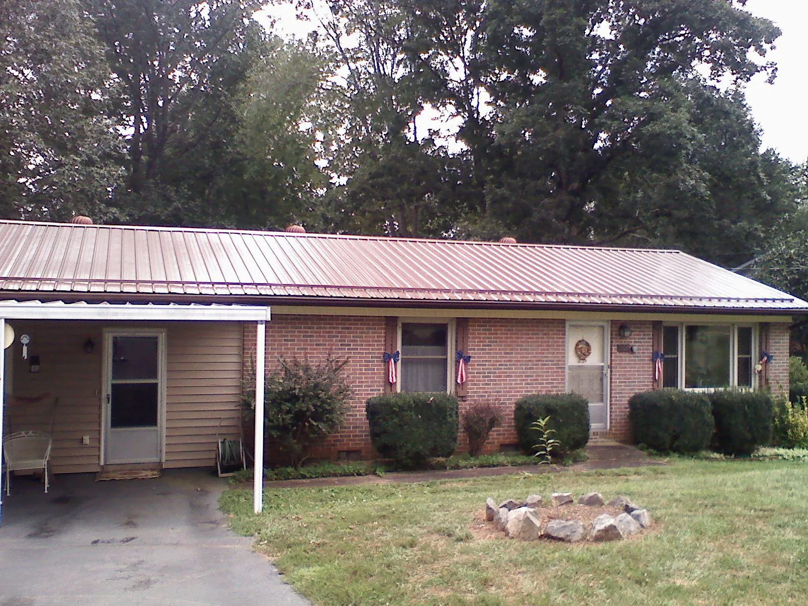 Bronze metal roof and carport on a brick ranch home — Roof Repair work by our crew in Ruther Glen